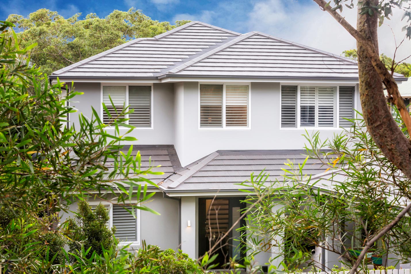 Front view of a bungalow home with trees.